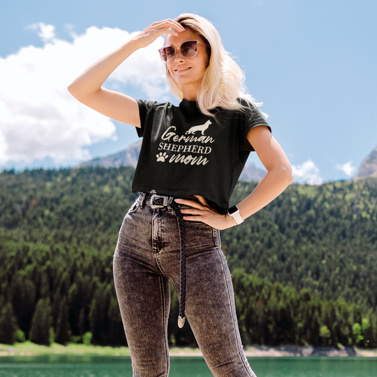 Woman wearing black German Shepherd Mom crop top outdoors by a mountain lake