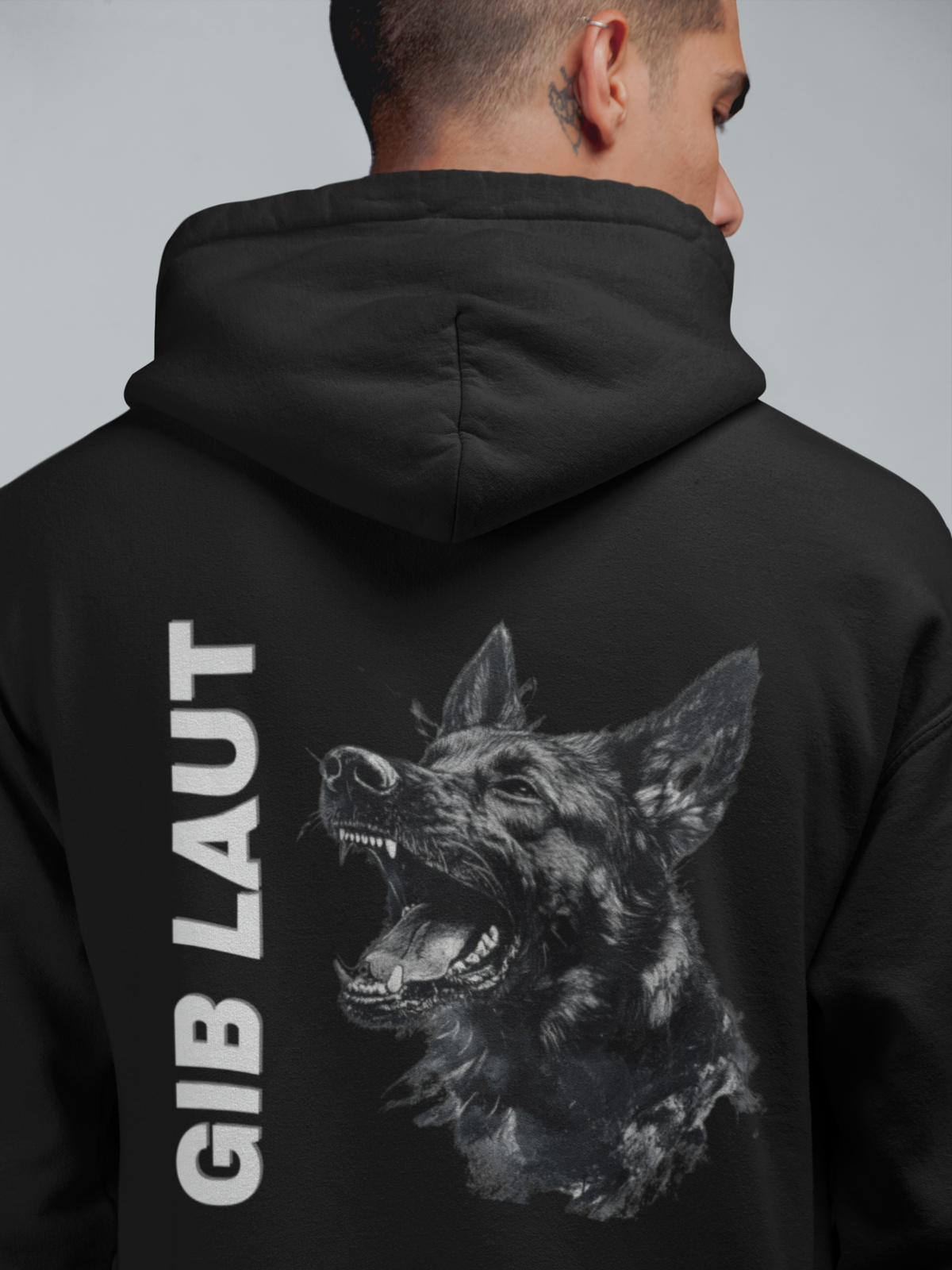 Man wearing black Gib Laut German Shepherd hoodie with German dog command design
