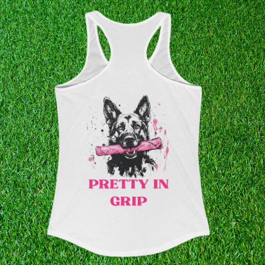 Woman's white racerback tank top with a German Shepherd holding a pink bite tug and the words Pretty In Grip, shown on grass