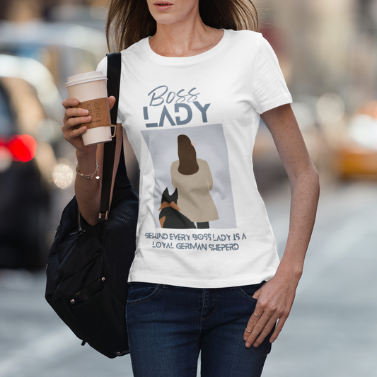 Woman wearing white Boss Lady German Shepherd t-shirt on city street with coffee and bag